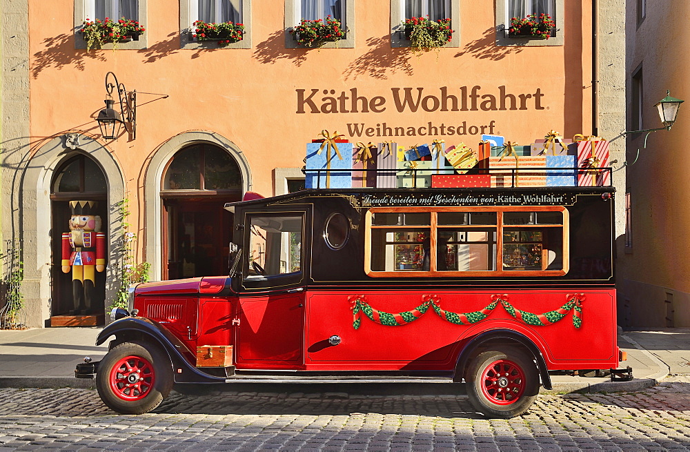 Germany, Bavaria, Rothenburg ob der Tauber, Kathe Wohlfahrt Christmas shop with present laden truck outside.