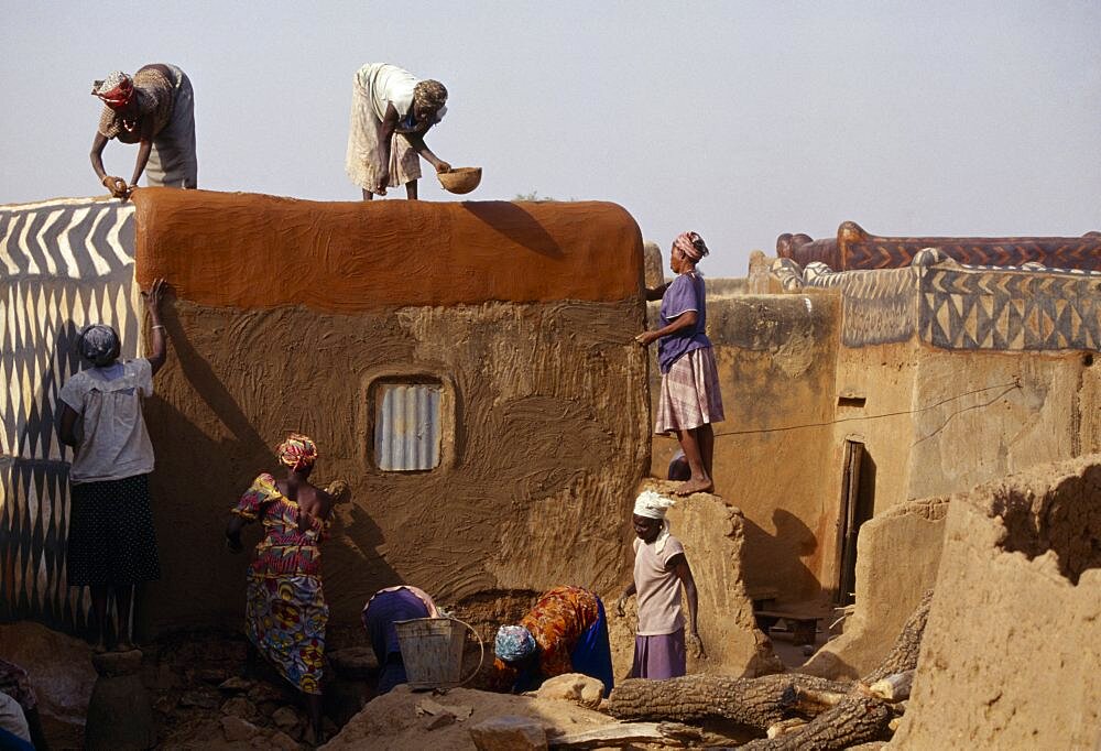 BURKINA FASO  Tiebele Group of women preparing house front for decorative painting in traditional Gourounsi village.