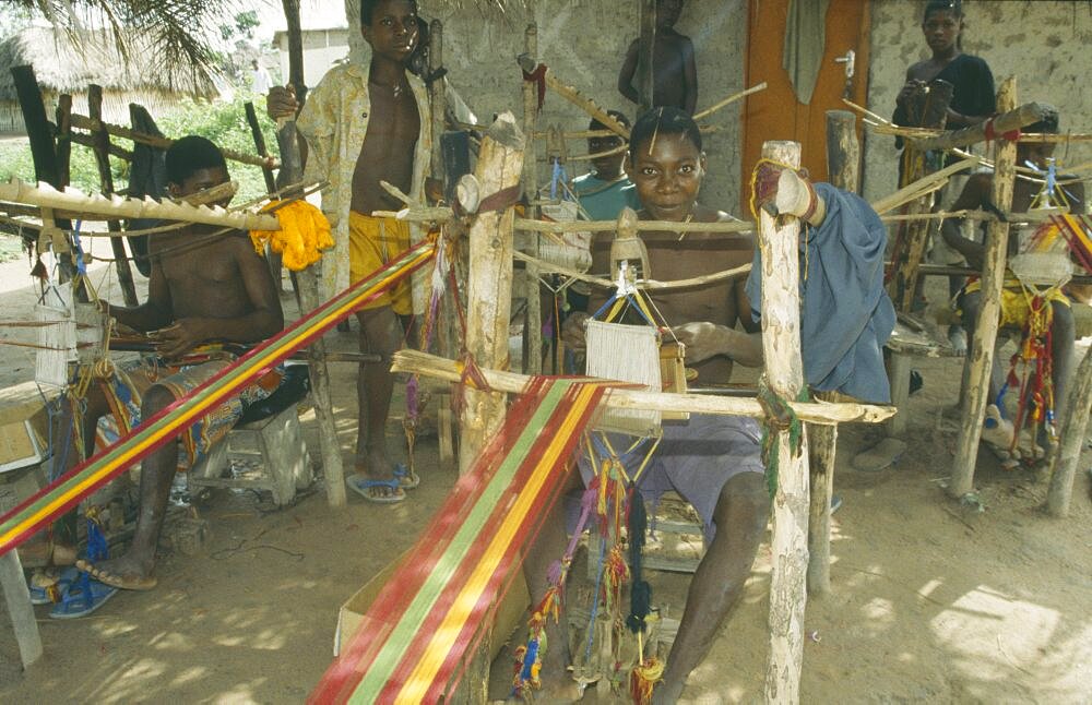 GHANA Ashanti Region Kumasi Weaver at hand loom prodcungin traditional multi coloured Kente cloth Asante Colored