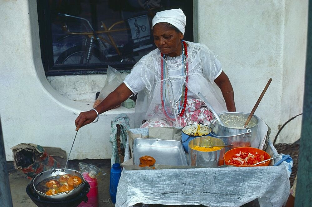 BRAZIL  Bahai Woman cooking on street stall serving traditional slave food.  Brasil