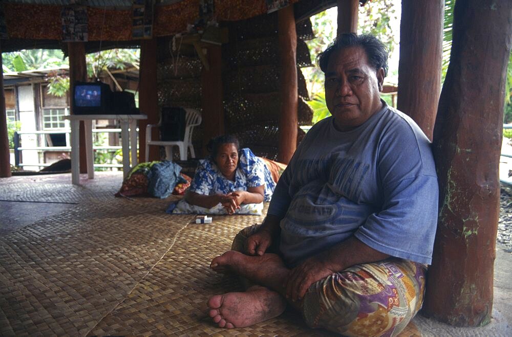 PACIFIC ISLANDS Western Samoa A Western Samoan tribal chief or Matai sitting on matting on floor inside house with television behind.