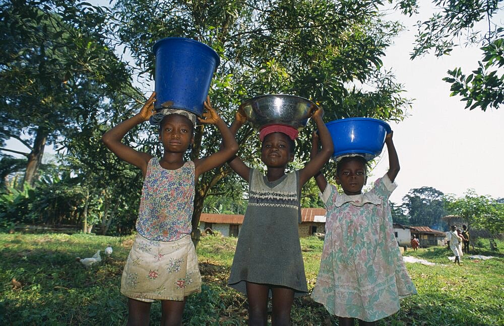 LIBERIA    Nimba Saclepea Three children carrying water vessels on their heads.