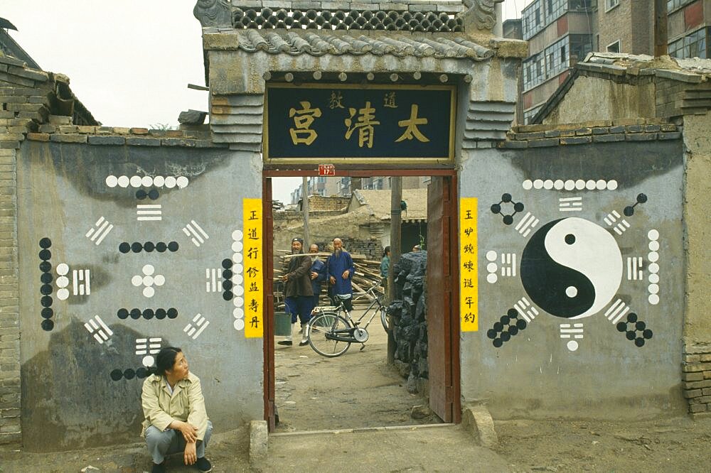 MONGOLIA Buddhism Yin and Yang painting on wall with woman sat on ground looking up at it