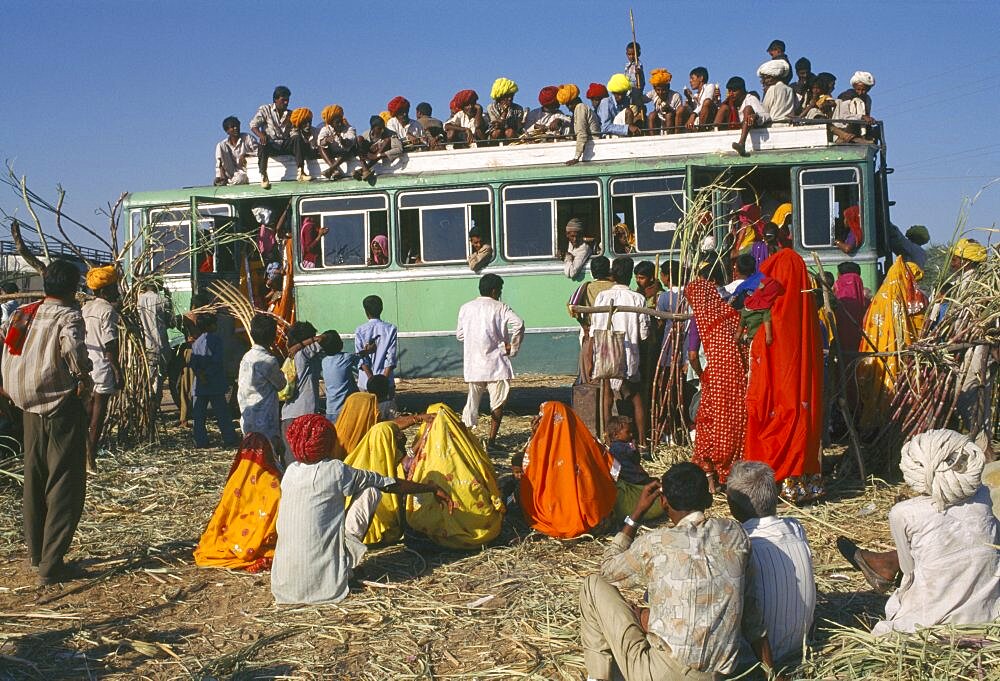 INDIA Rajasthan Pushkar Over crowded bus with passengers on the roof