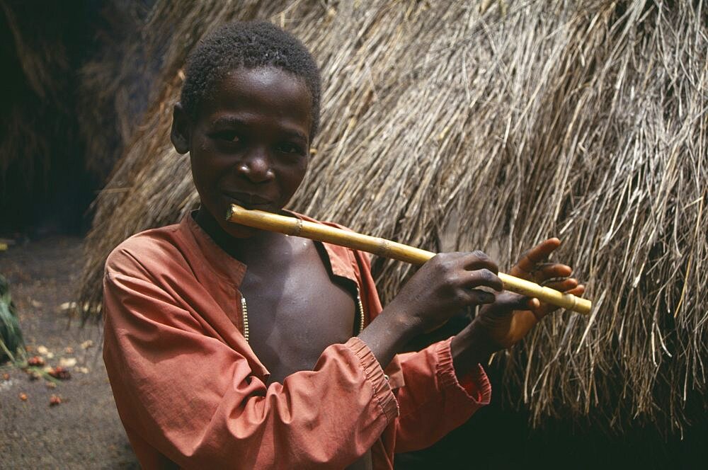 SIERRA LEONE  Kambia Young boy playing home made flute.