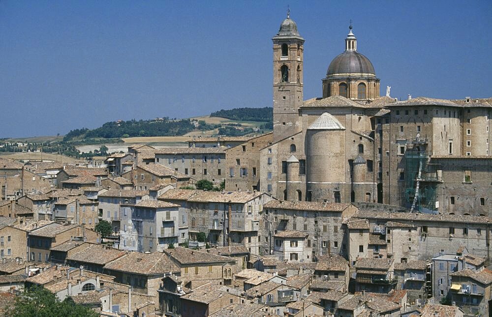 ITALY Marche Urbino Palazzo Ducale rising above city rooftops.  Built for Duke Federico da  Montefeltro the ruler of Urbino between 1444 and 1482.