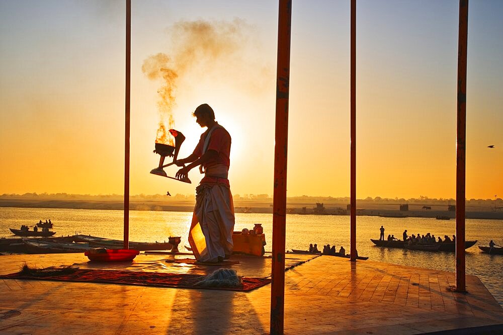 INDIA Uttar Pradesh Varanasi Performing the Ganga Aarti Ceremony at dawn over the River Ganges. India Varanasi Uttar Pradesh Aarti Ceremony River Ganges Faith Hindu Hinduism Tradition Dawn Perform Holy Sacred Sunrise Travel Tourism Holidays Asia Sub-Continent Act Asian Bharat Inde Indian Intiya Performance Public Presentation Religion Religious Hinduism Hindus One individual Solo Lone Solitary