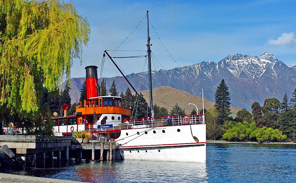 NEW ZEALAND SOUTH ISLAND OTAGO QUEENSTOWN  VINTAGE STEAMSHIP TSS EARNSALW DOCKED AT STEAMER WHARF QUEENSTOWN WHICH TAKES TOURISTS FOR CRUISES ON LAKE WAKATIPU WITH THE REMARKABLES MOUNTAINS BEHIND. Antipodean Oceania