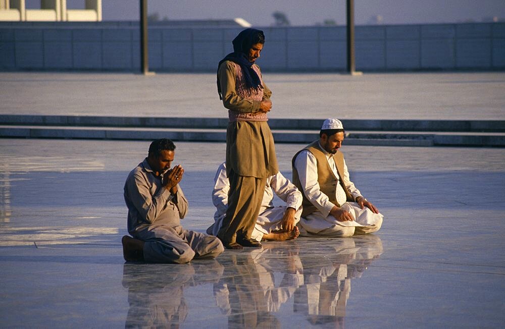 Faisal Mosque, Four men at prayer reflected in surface of shiny marble floor, Islamabad, Pakistan