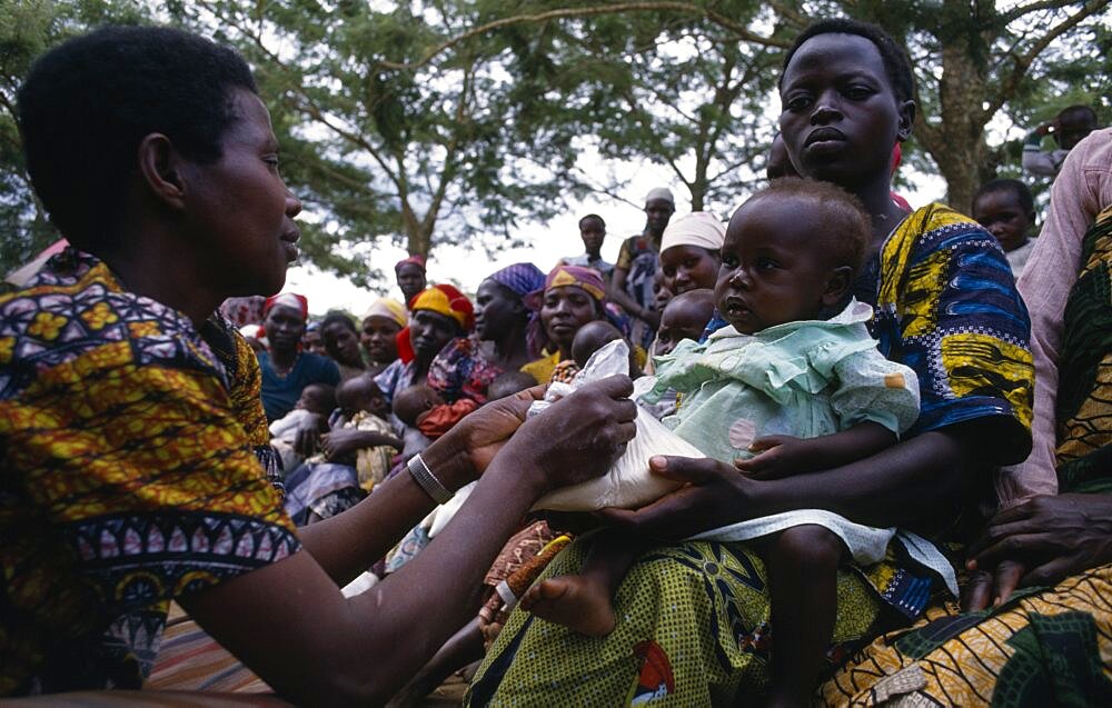 Health worker giving nutritional advice to mothers with vulnerable babies during food distribution at Orukinga refugee camp near the Rwandan border, Medical, Uganda