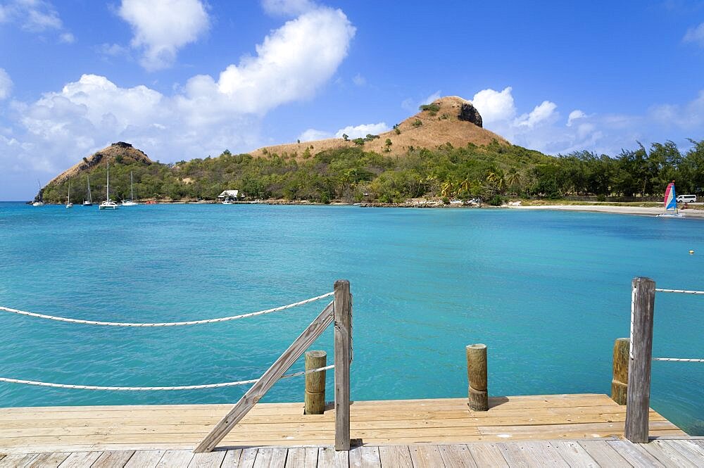 Pigeon Island National Historic Park seen from a nearby wooden jetty with yachts at anchor in Rodney Bay, Gros Islet, St Lucia