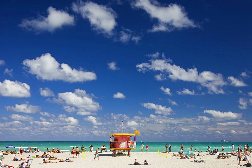 Crowded beach scene with pink lifeguard hut, Miami, Florida, United States of America