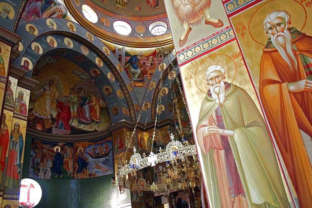 Nazareth, Interior of the Greek Orthodox Church of St, Gabriel also known as the Church of the Annunciation part view of domed roof and archways decorated with paintings of biblical scenes and the saints wall hangings and tiled mosaics, Church is located over the spring that fed Marys Well, Sea of Galilee, Hazafon, Israel