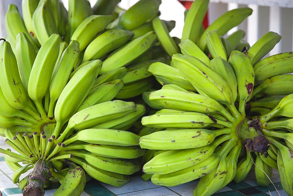 Hillsborough Bundles of green bananas on a stall in the main street, Caribbean