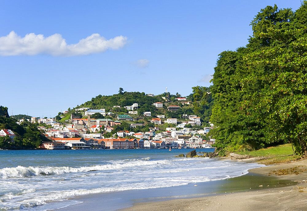 The hillside buildings and waterfront of the Carenage in the capital St Georges seen from Pandy Beach beside Port Louis Marina, Caribbean