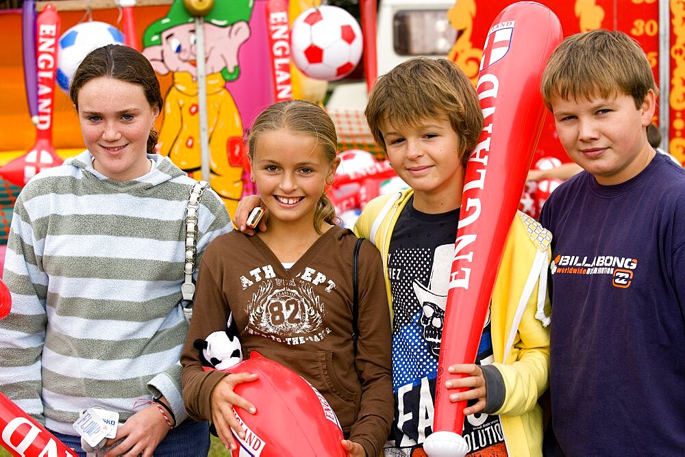 Findon village Sheep Fair Two teenage boys and two girls holding prizes won at fairground stalls, United Kingdom