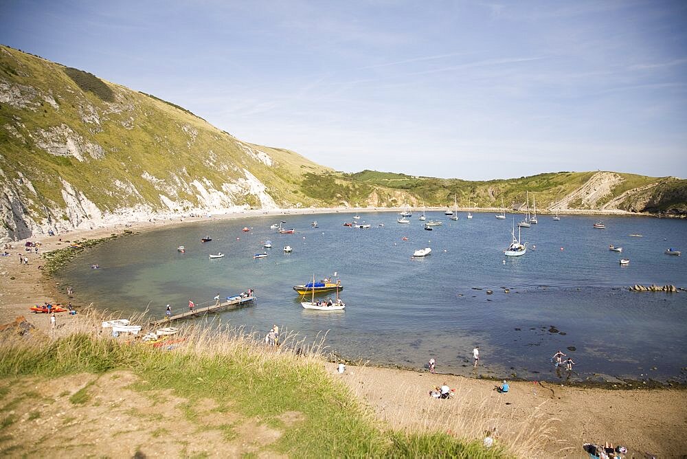 England, Dorset, Lulworth Cove, busy beach scene with sunbathers
