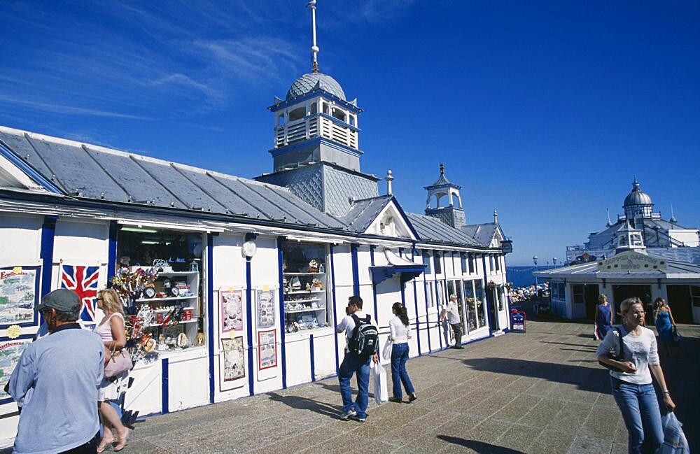 England, East Sussex, Eastbourne, Pier gift shops with visitors walking past