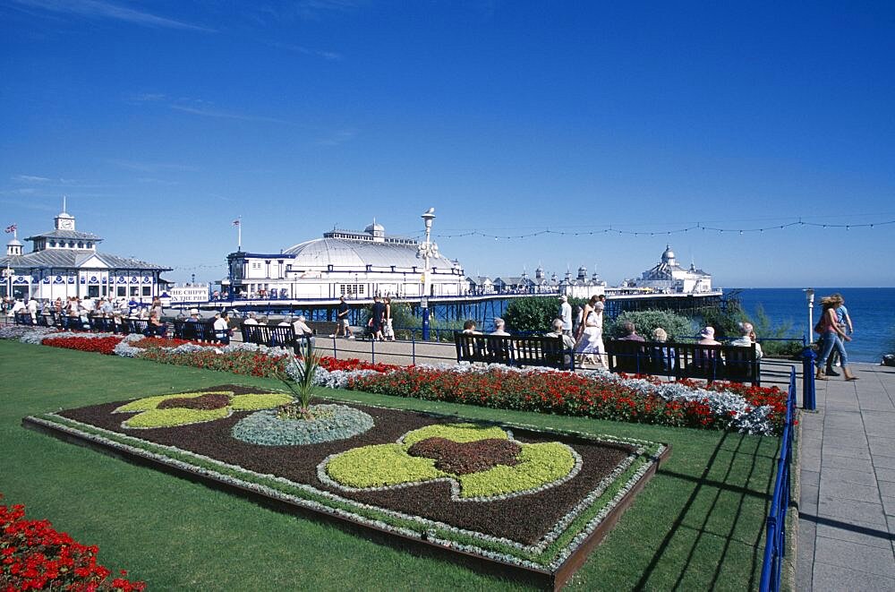 England, East Sussex, Eastbourne, Seafront promenade formal flowerbed display with pier behind