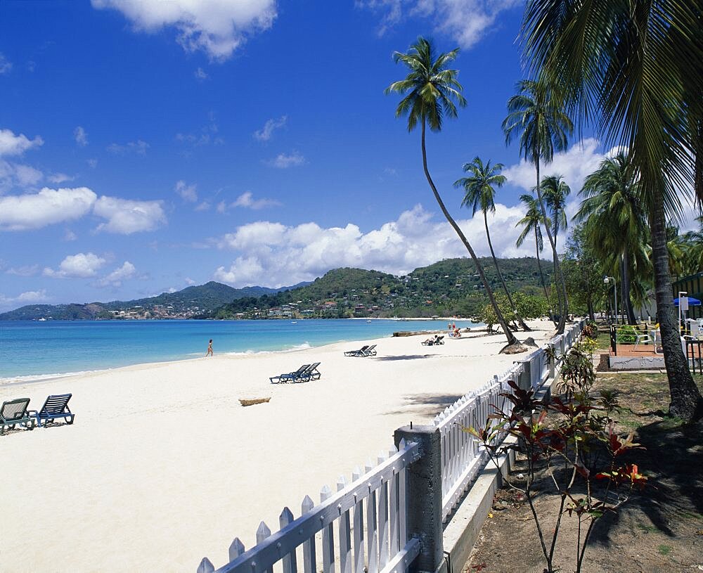 WEST INDIES Grenada Grand Anse Beach View along empty sandy beach towards turquoise sea and hills seen from across water