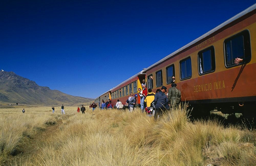 PERU Puno Administrative Department La Raya Train stopped on the altiplano at the highest pass on the line between Puno to Cusco.  People disembarking.