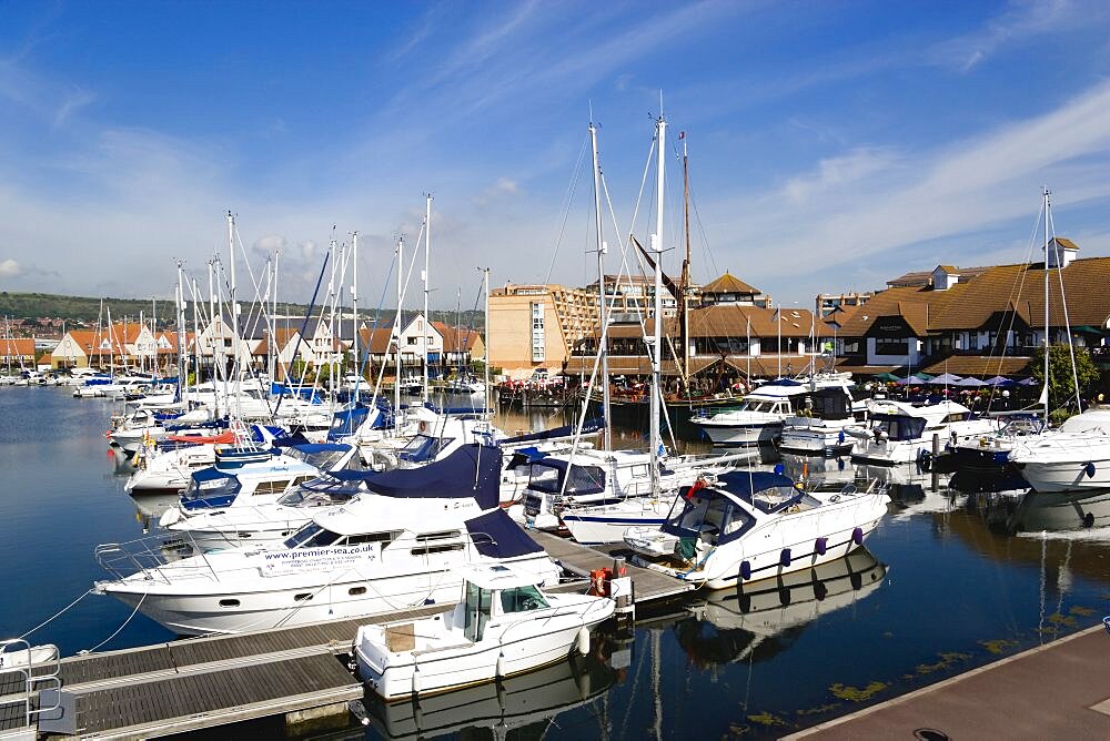 England, Hampshire, Portsmouth, Port Solent with boats moored with restaurants a pub and housing surrounding the Marina.