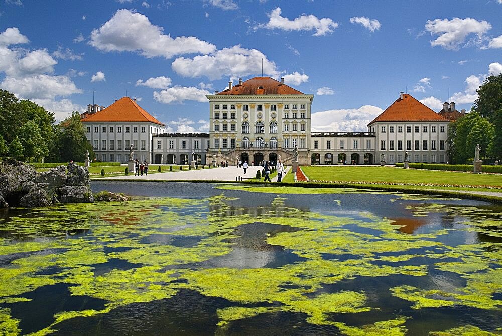 Germany, Bavaria, Munich, Nymphenburg Palace. Baroque exterior facade set in formal gardens with lake in foreground.