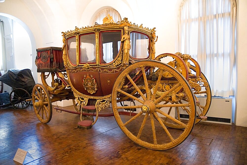 Germany, Bavaria, Munich, Nymphenburg Palace Marstall Museum. Highly ornate gold and painted coach made for the coronation of King Max I Joseph in 1818.