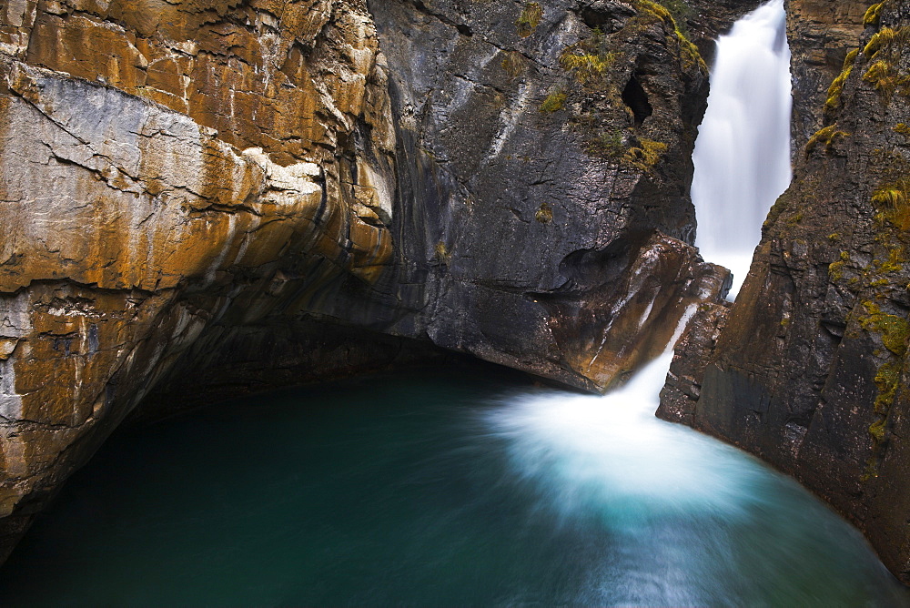 A raging waterfall carves through the rock at Johnston Canyon, Canada, North America