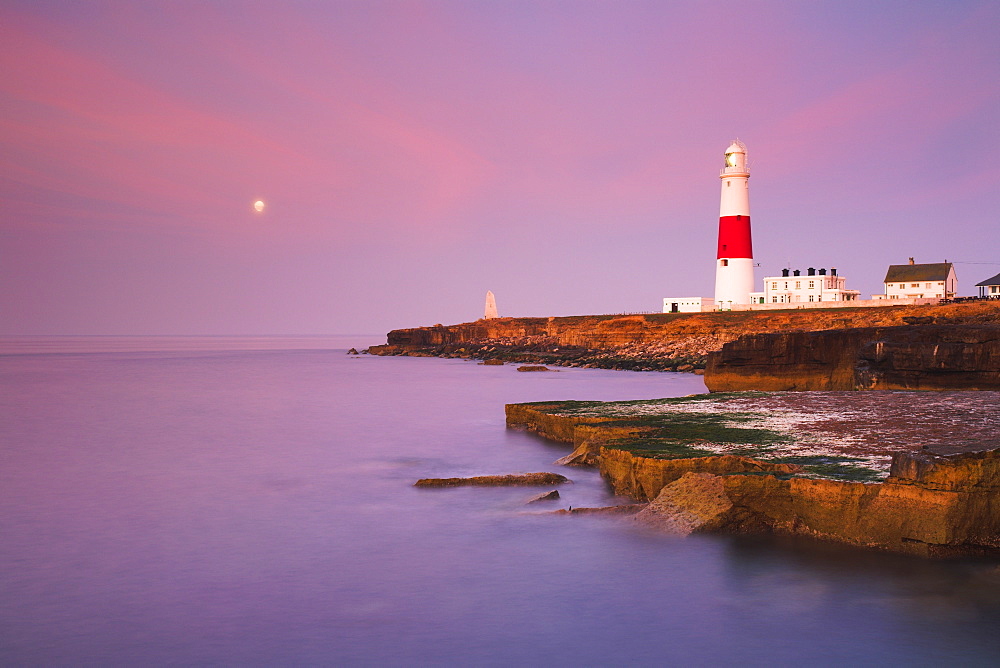 A full moon in the dawn sky over Portland Bill lighthouse, Jurassic Coast, UNESCO World Heritage Site, Dorset, England, United Kingdom, Europe