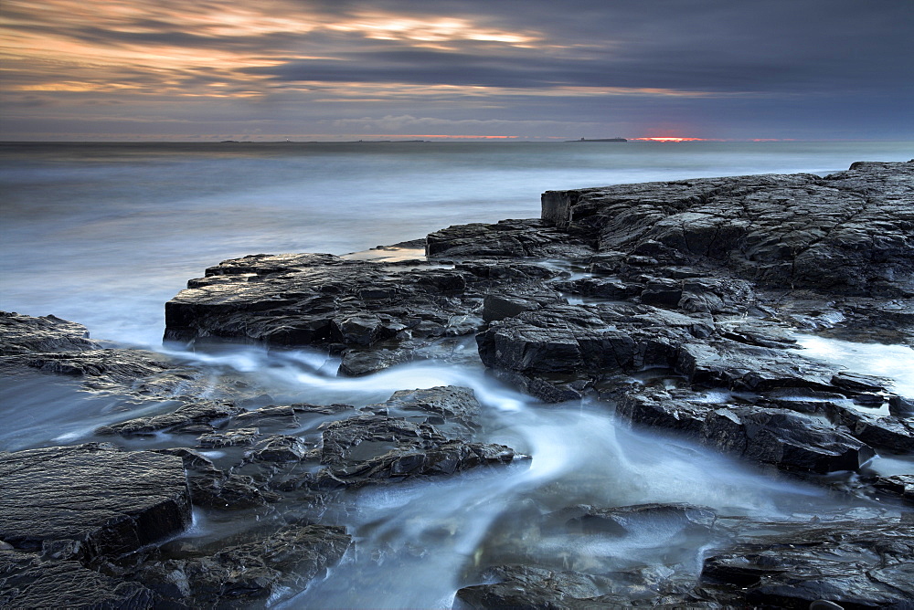 Dawn over the distant Farne Islands from the Bamburgh coast, Northumberland, England, United Kingdom, Europe