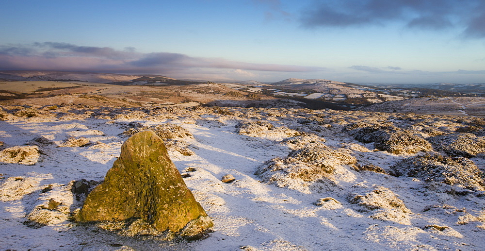 Early morning sunshine lights up the snow covered winter landscape near Haytor Rocks in Dartmoor National Park, Devon, England, United Kingdom, Europe