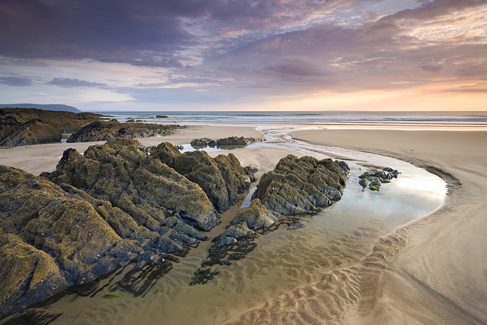 Sunset on the rocky and sandy beach at Coombesgate, Woolacombe, Devon, England, United Kingdom, Europe