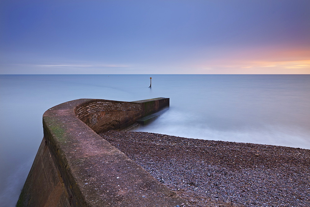 Stone jetty on Sidmouth beachfront at sunset, Sidmouth, Devon, England, United Kingdom, Europe