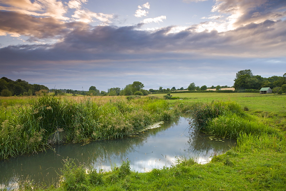 The River Windrush meanders through water meadows just outside the Cotswolds town of Burford, Oxfordshire, England, United Kingdom, Europe 