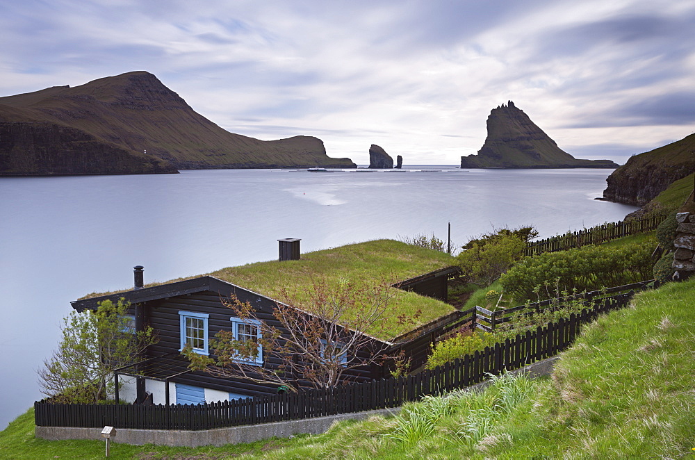 Traditional grass roofed house in the village of Bour, with views to Tindholmur, Vagar, Faroe Islands, Denmark, Europe