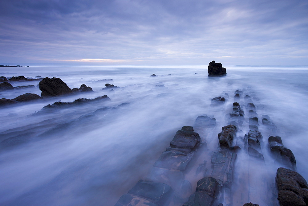 Waves rush over the rocky ledges at Sandymouth Bay in North Cornwall, England, United Kingdom, Europe