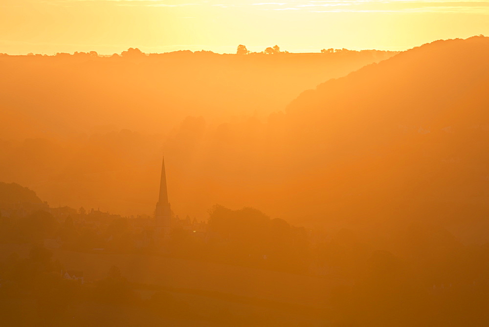 Painswick Church in the Cotswolds at sunrise on a misty autumn morning, Gloucestershire, England, United Kingdom, Europe