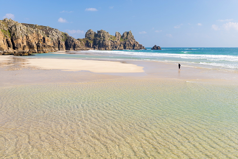 Woman walking alone on Pednvounder Beach at low tide, Porthcurno, Cornwall, England, United Kingdom, Europe