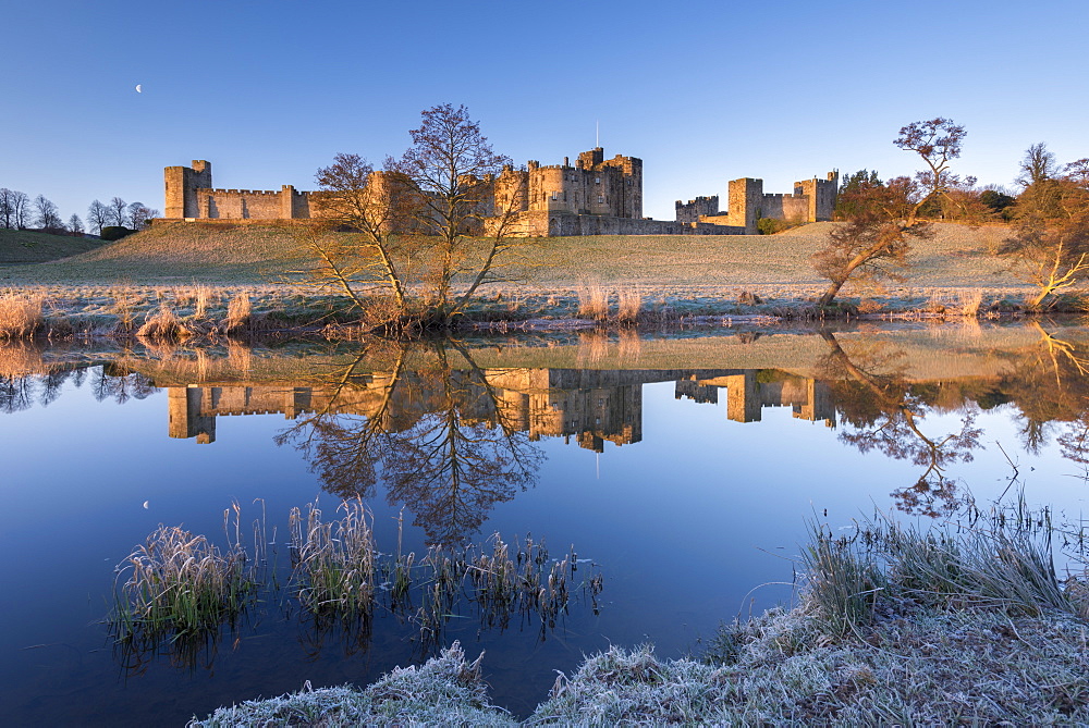 Early morning sunshine in winter illuminates Alnwick Castle in Northumberland, England, United Kingdom, Europe