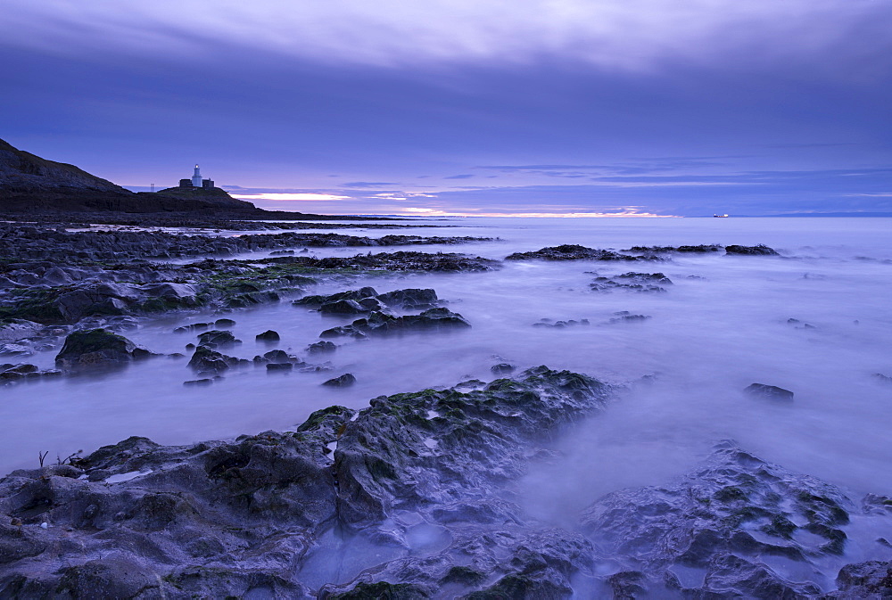 Mumbles lighthouse at dawn in winter from Bracelet Bay, Swansea, Wales, United Kingdom, Europe