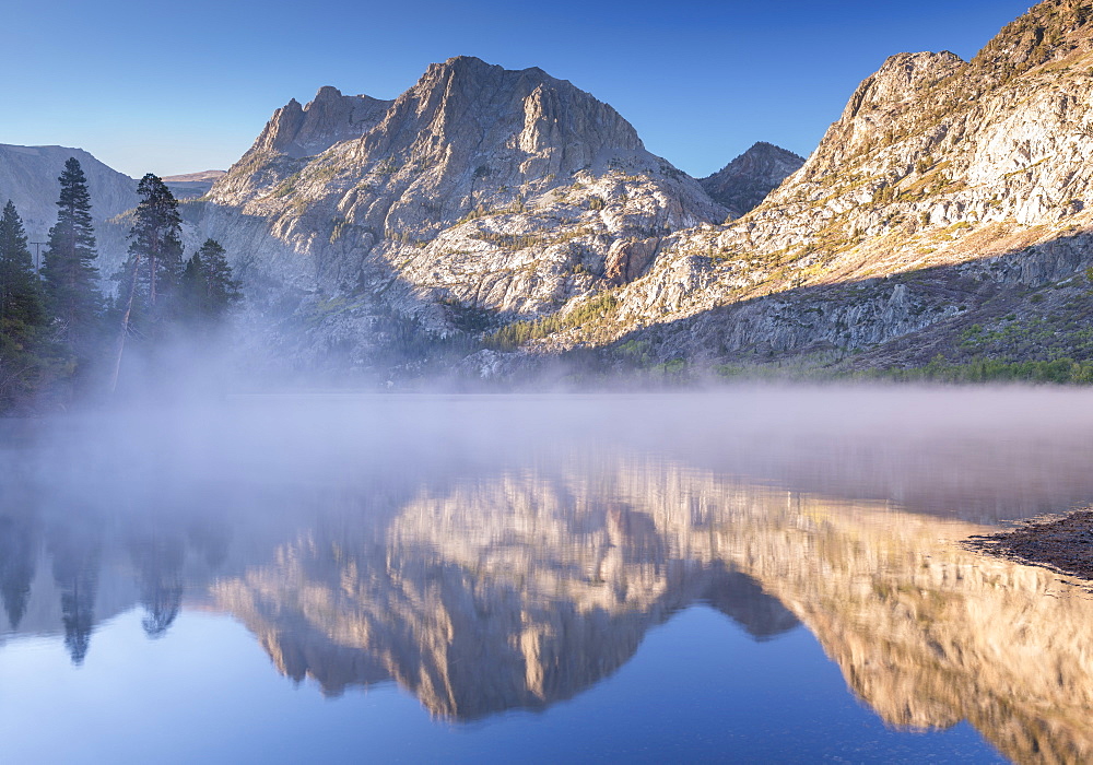 Carson Peak, reflected in the mist shrouded waters of Silver Lake on the June Lake Loop, Eastern Sierras, California, United States of America, North America