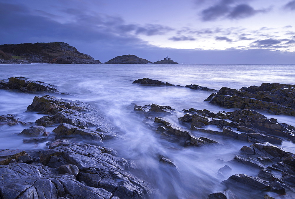 Rocky shore of Bracelet Bay, looking across to Mumbles lighthouse, Mumbles, Wales, United Kingdom, Europe