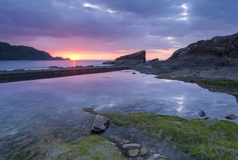 Sunset reflected in a rock pool at Combe Martin on the Exmoor coast, North Devon, England, United Kingdom, Europe