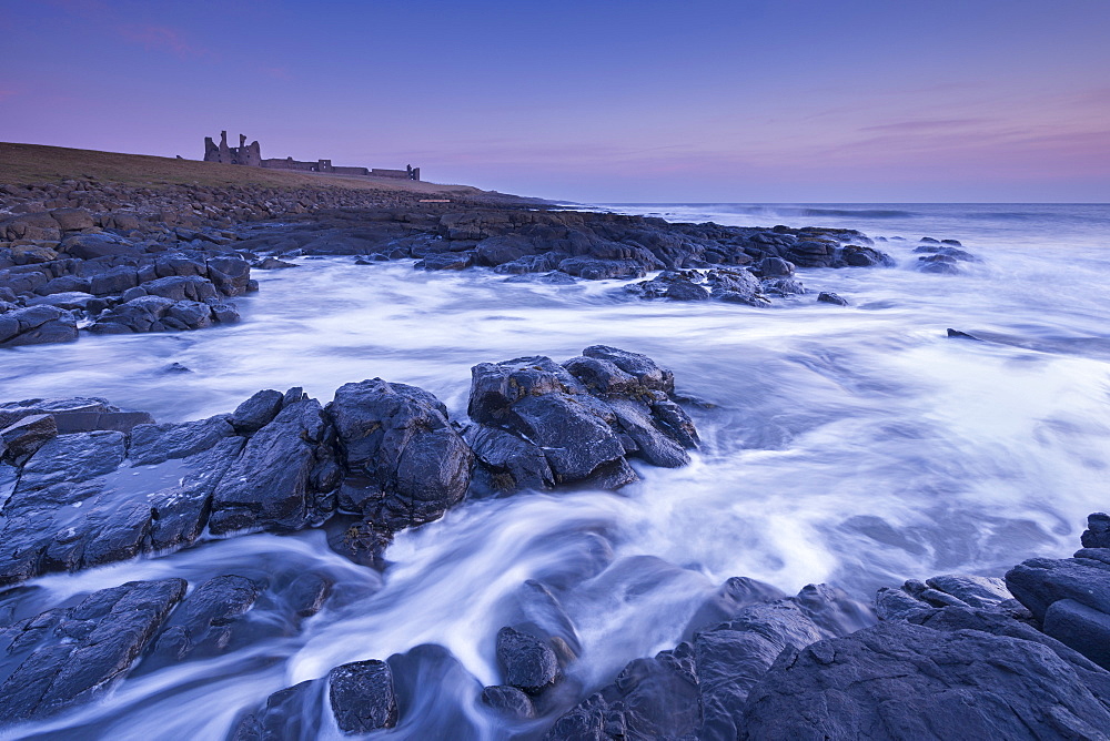 Dunstanburgh Castle at dawn, Craster, Northumberland, England, United Kingdom, Europe