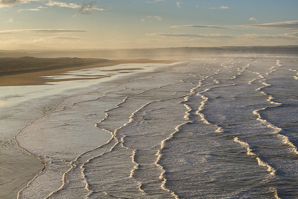 Breaking waves roll towards Saunton Sands at dawn in winter in North Devon, England, United Kingdom, Europe