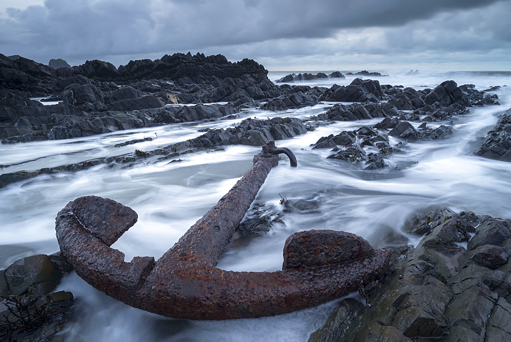 Large rusted anchor from a shipwreck on rocky seashore, Devon, England, United Kingdom, Europe