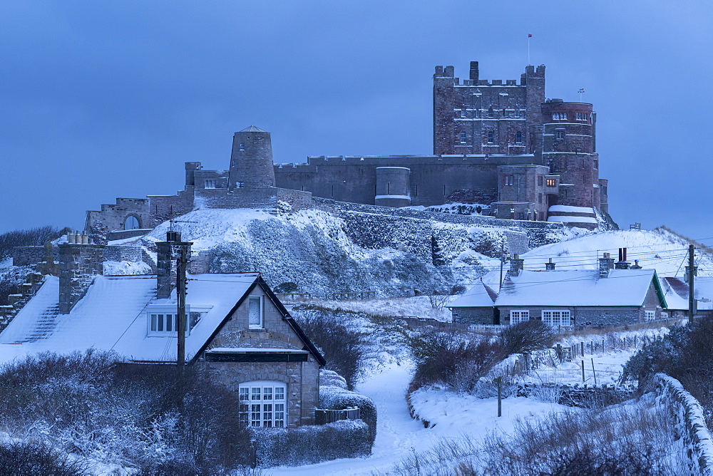 Bamburgh village and Castle in deep winter snow, Northumberland, England, United Kingdom, Europe