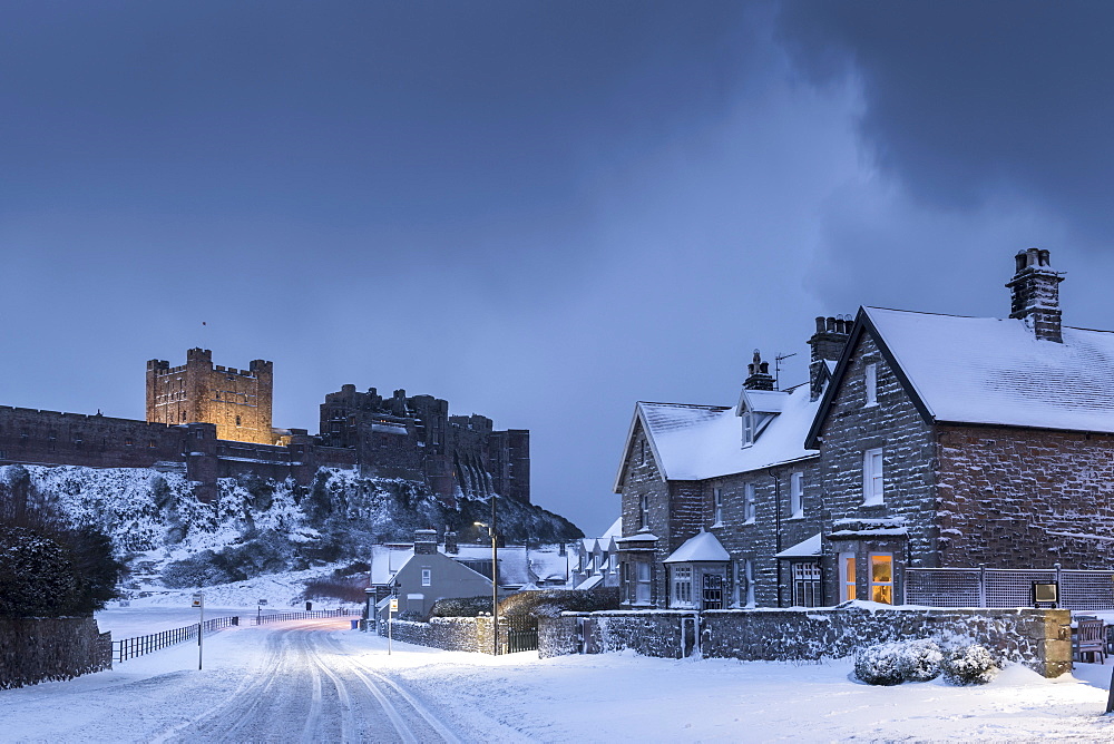 Bamburgh Castle and village in winter snow, Northumberland, England, United Kingdom, Europe