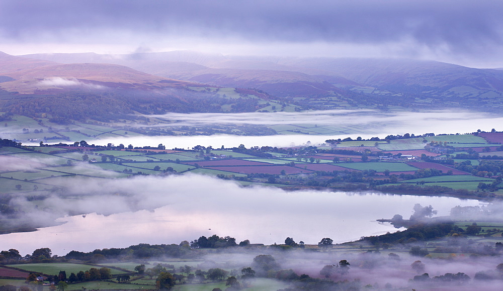 Llangorse Lake and the Brecon Beacons mountain range at dawn on a misty morning, Brecon Beacons National Park, Powys, Wales, United Kingdom, Europe